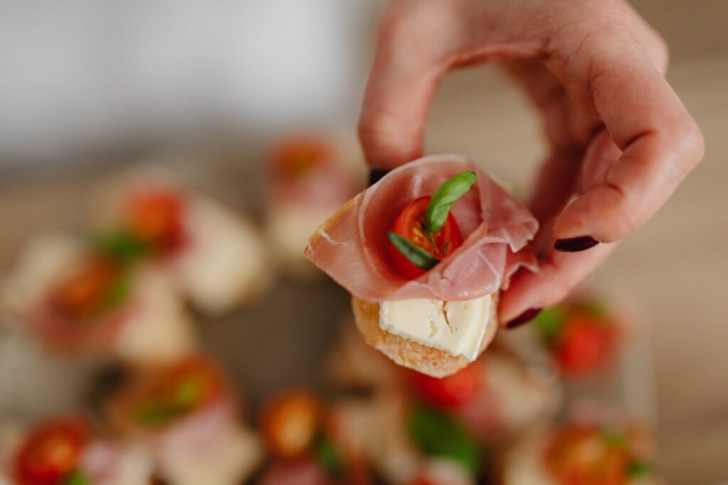 Person Holding a Piece of Bread with Meat