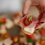 Person Holding a Piece of Bread with Meat